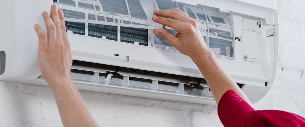 close-up-shot-of-professional-repairman-changing-f-UECX6PF (1) close-up shot of professional repairman changing filter for air conditioner hanging on white brick